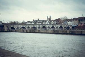 a bridge over a body of water with buildings in the background